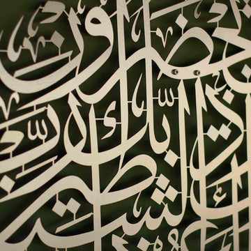 لقطة مقربة لحروف معدنية فضية بدعاء الحماية من الشر على جدار زيتوني تُظهر المسامير الجدارية