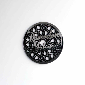 Smaller Silver Ramadan Mubarak circular wall decor on a white wall, seen from a distance
