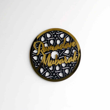 Gold circular Ramadan Mubarak wall decor, small in frame on a white wall