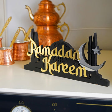 ديكور طاولة «رمضان كريم» ذهبي بقبة مسجد ومآذن بجانب إبريق شاي نحاسي على سطح المطبخ
