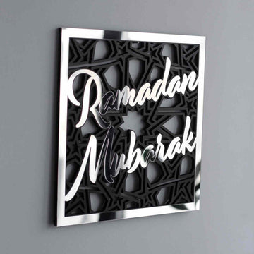Large silver Ramadan Mubarak square wall art with black star pattern, close view on a gray wall